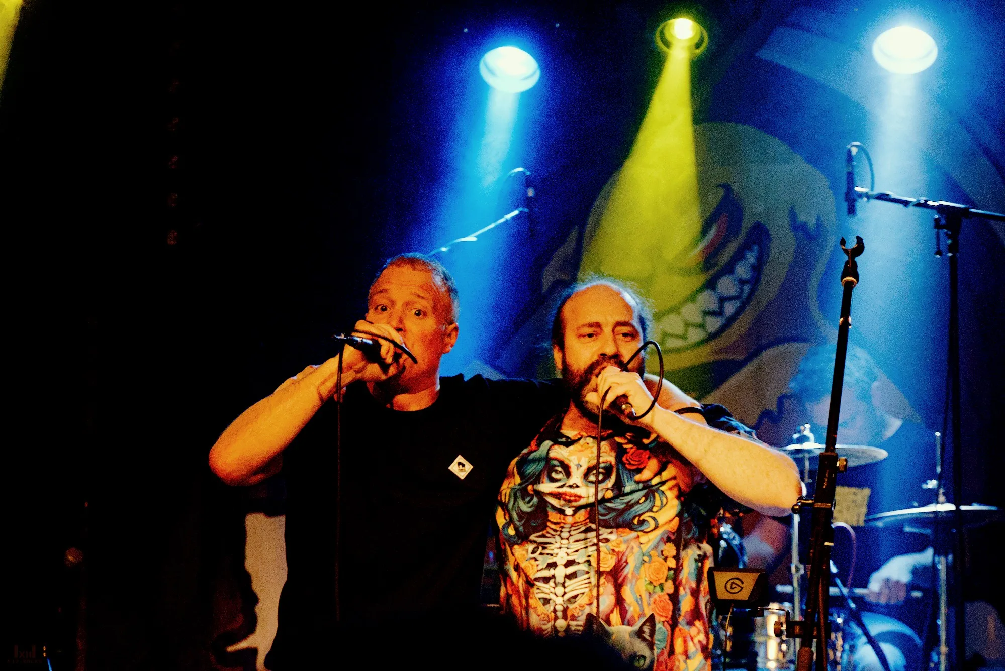 Die beiden Sänger von Rockoholic performen vor blau-gelbem Bühnenlicht